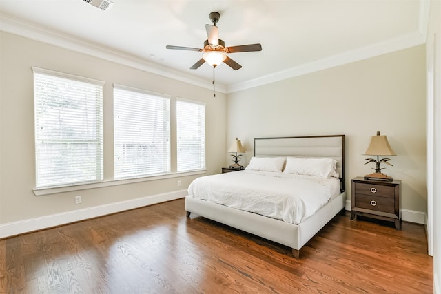 bedroom featuring ceiling fan, dark wood-type flooring, multiple windows, and ornamental molding