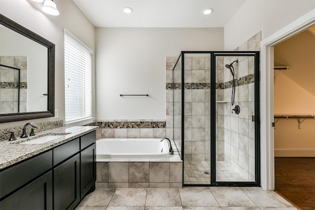 bathroom featuring vanity, plenty of natural light, tile patterned floors, and plus walk in shower