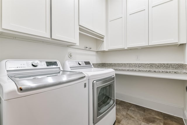 clothes washing area with cabinets and washing machine and clothes dryer