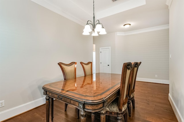 dining room with dark hardwood / wood-style flooring, crown molding, and a chandelier