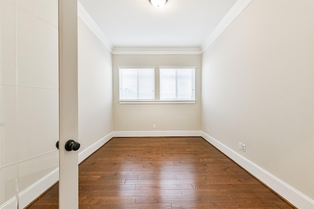 spare room featuring wood-type flooring and crown molding