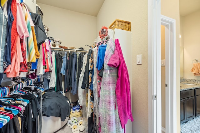 walk in closet featuring light colored carpet and sink