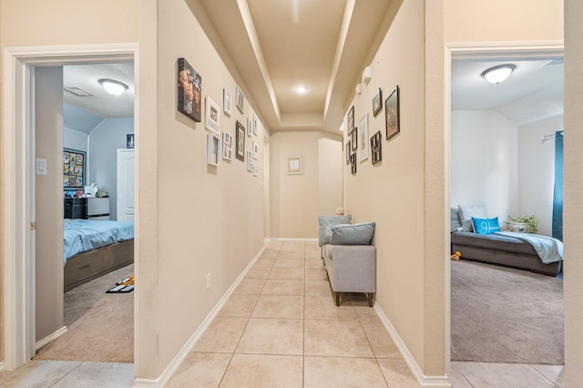 corridor with vaulted ceiling and light colored carpet