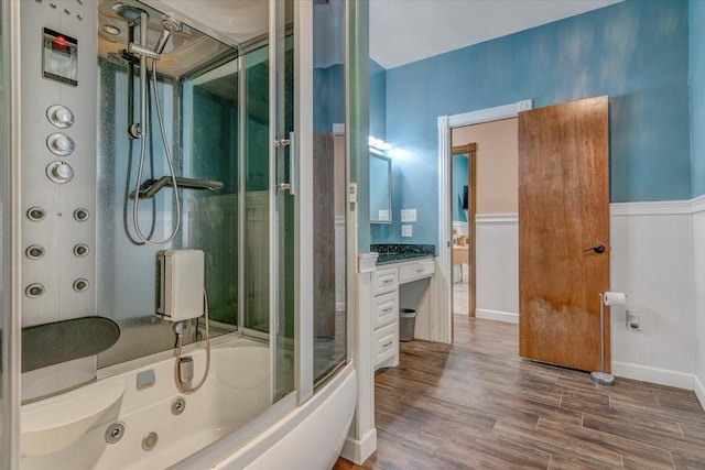 bathroom featuring wood-type flooring, vanity, and shower / bath combination with glass door