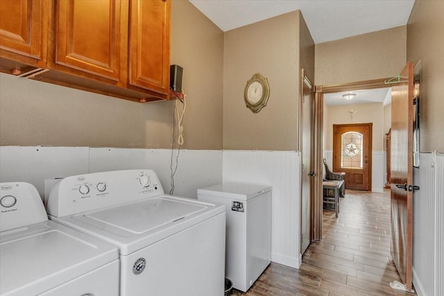 clothes washing area with washing machine and dryer and wood-type flooring