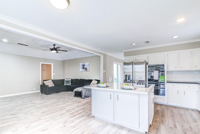 kitchen with white cabinets, a kitchen island, stainless steel refrigerator with ice dispenser, double oven, and decorative backsplash