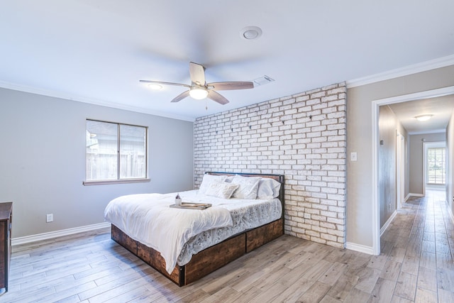 bedroom featuring ceiling fan, light wood-type flooring, and crown molding