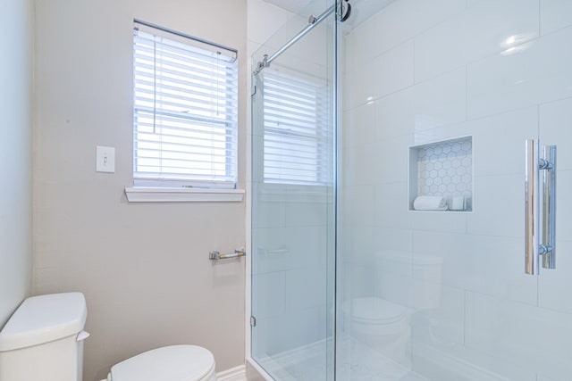 bathroom featuring toilet and an enclosed shower