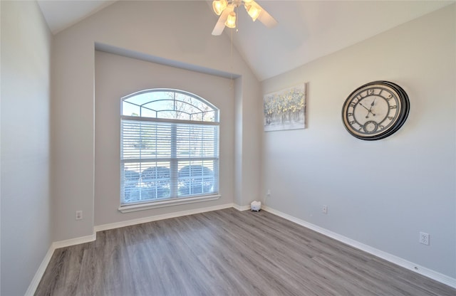 empty room with ceiling fan, wood-type flooring, lofted ceiling, and a wealth of natural light