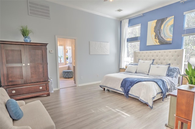 bedroom featuring light hardwood / wood-style floors, crown molding, connected bathroom, and multiple windows