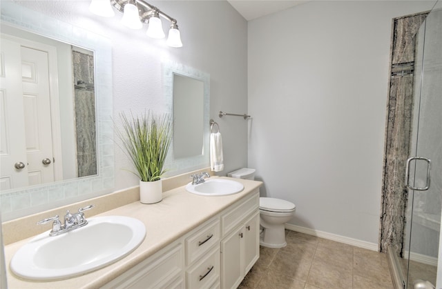 bathroom featuring vanity, toilet, tile patterned floors, and walk in shower