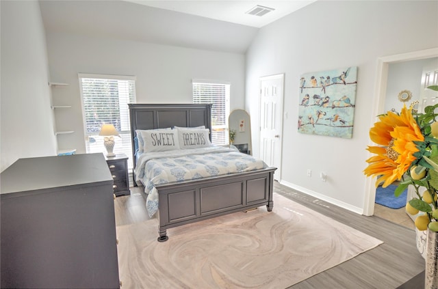 bedroom with vaulted ceiling and light hardwood / wood-style floors