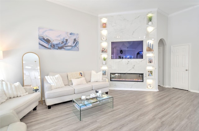 living room featuring crown molding, a fireplace, and hardwood / wood-style flooring