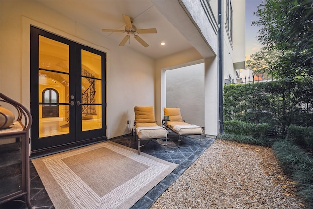 patio terrace at dusk featuring ceiling fan and french doors