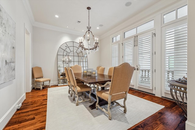 dining area with dark wood-type flooring, an inviting chandelier, and ornamental molding