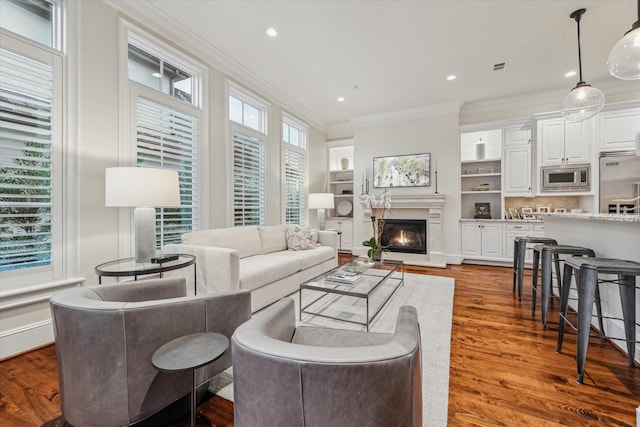 living room featuring a healthy amount of sunlight, crown molding, and hardwood / wood-style floors