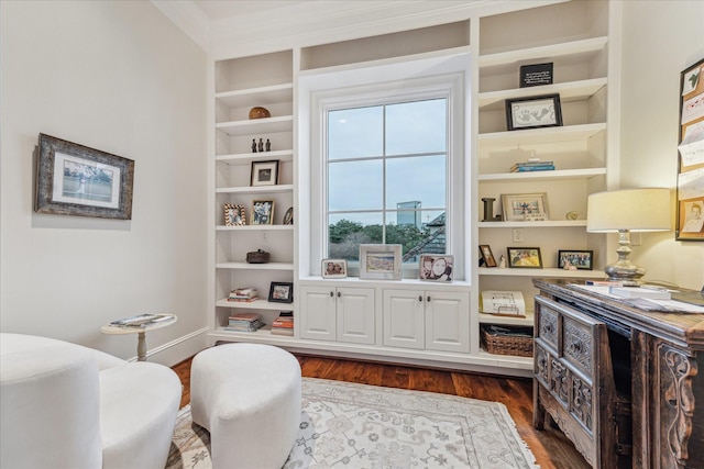 sitting room featuring built in shelves and dark wood-type flooring