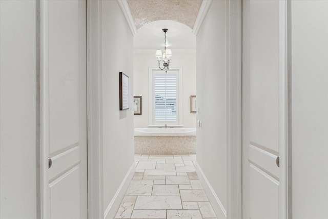 hallway featuring an inviting chandelier and crown molding