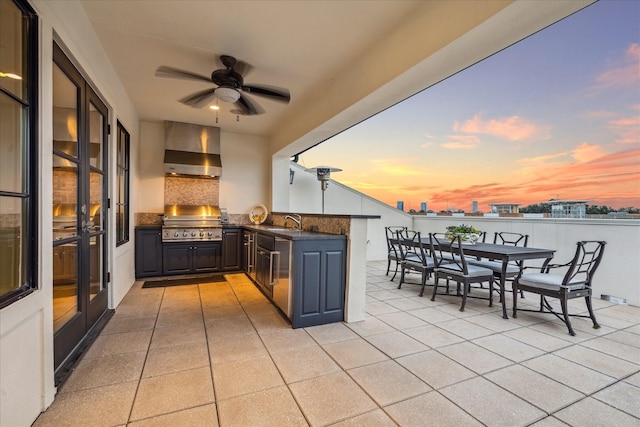 patio terrace at dusk featuring sink, grilling area, and area for grilling