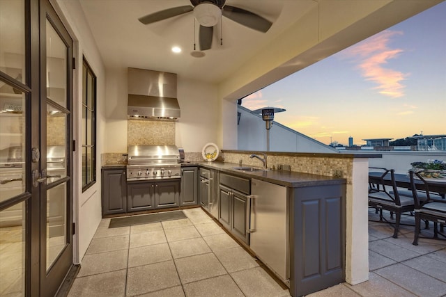 kitchen featuring ceiling fan, sink, kitchen peninsula, and wall chimney range hood