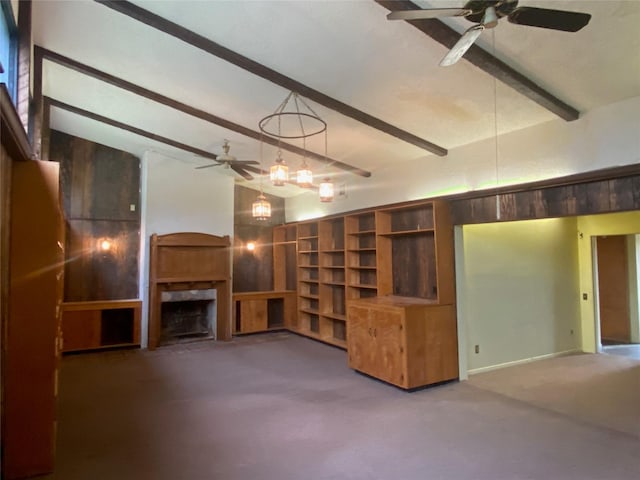 unfurnished living room featuring ceiling fan, built in features, wooden walls, and vaulted ceiling with beams