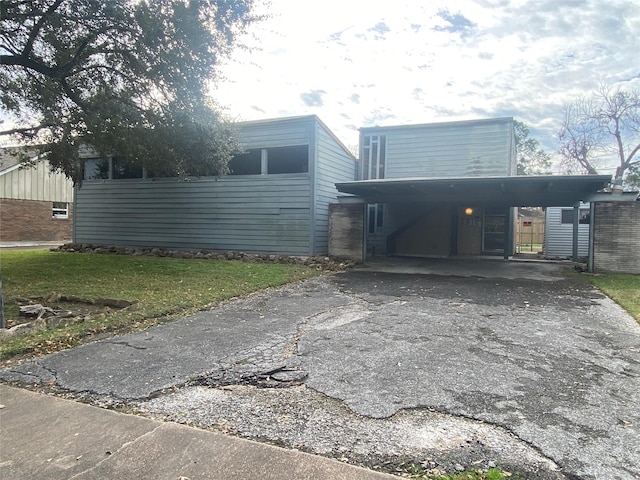 view of side of home featuring a lawn and a carport