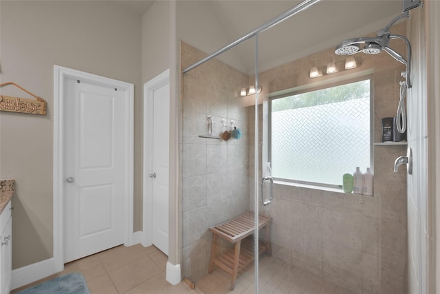 bathroom with tile patterned flooring, a shower with shower door, and vanity