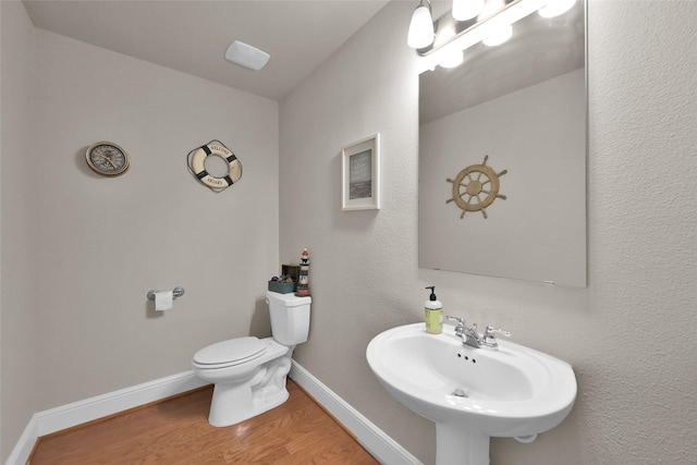 bathroom featuring toilet, sink, and hardwood / wood-style floors