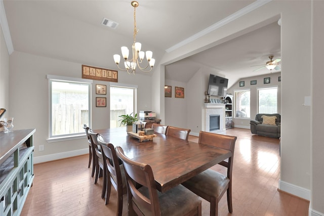 dining room featuring a fireplace, lofted ceiling, ceiling fan with notable chandelier, and hardwood / wood-style floors