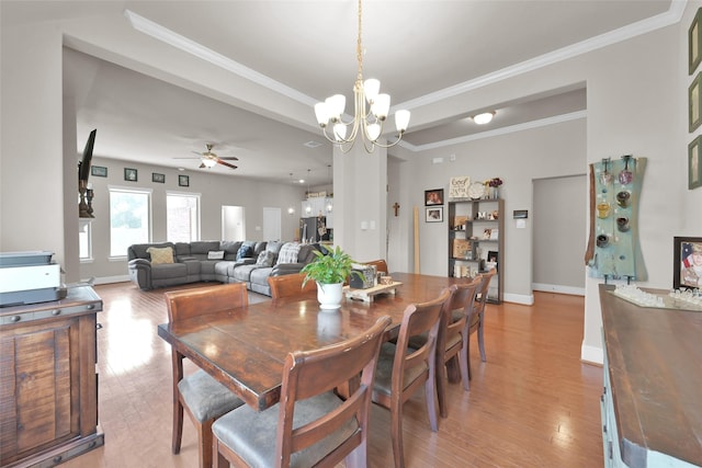 dining room with ceiling fan with notable chandelier, light hardwood / wood-style flooring, and ornamental molding