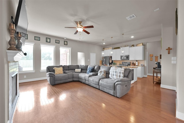 living room featuring ceiling fan and light wood-type flooring