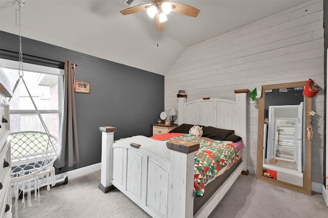 bedroom featuring ceiling fan, light colored carpet, wood walls, and lofted ceiling