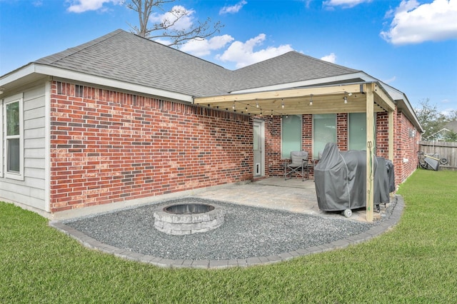 rear view of house featuring a lawn, an outdoor fire pit, and a patio area