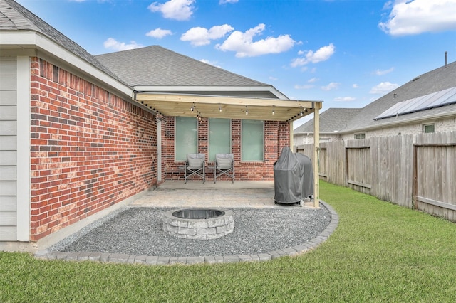 back of property featuring a patio area, an outdoor fire pit, and a yard