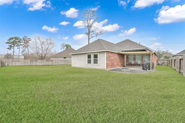 rear view of property with a lawn and a patio