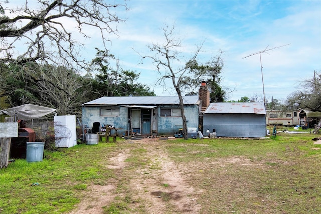 rear view of property featuring a lawn