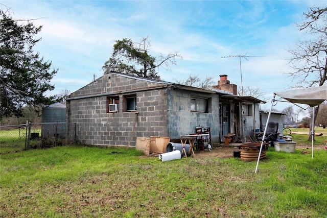 rear view of property featuring cooling unit and a yard