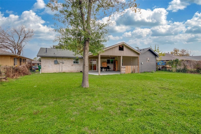 rear view of house featuring a yard and a patio