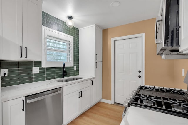 kitchen featuring light hardwood / wood-style floors, sink, white cabinetry, stainless steel appliances, and light stone counters