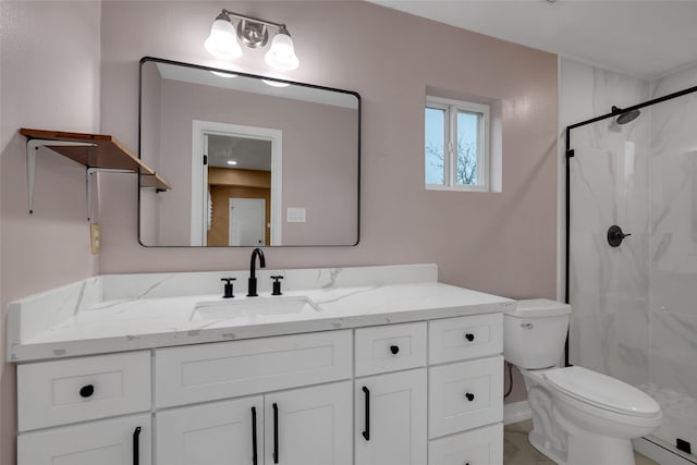 bathroom with a shower with shower door, vanity, and toilet