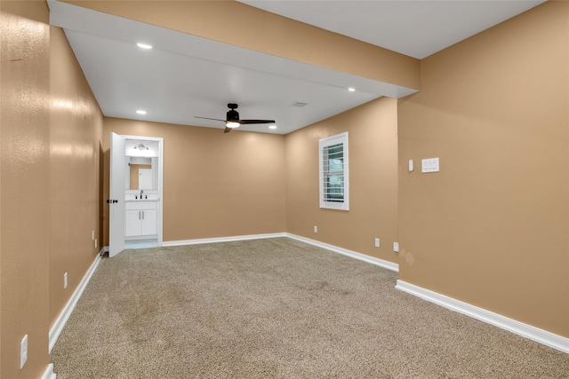 carpeted spare room with ceiling fan and sink