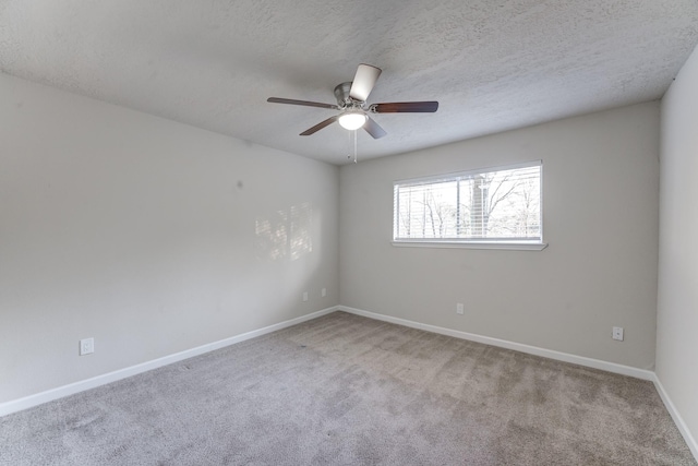 carpeted empty room featuring ceiling fan and a textured ceiling