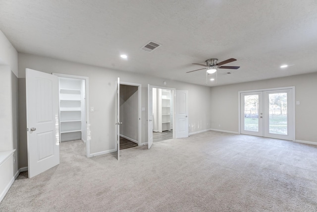 unfurnished bedroom featuring ceiling fan, a walk in closet, and a closet