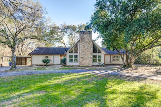 exterior space with a carport and a lawn