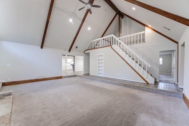 unfurnished living room with high vaulted ceiling, built in shelves, ceiling fan, and carpet flooring