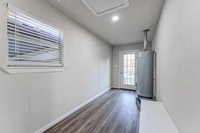 interior space with dark hardwood / wood-style flooring and water heater