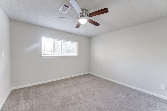 carpeted spare room featuring a textured ceiling and ceiling fan