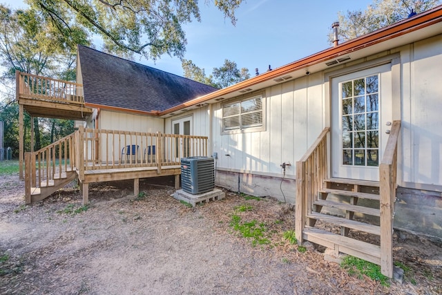 back of property with central AC unit and a wooden deck