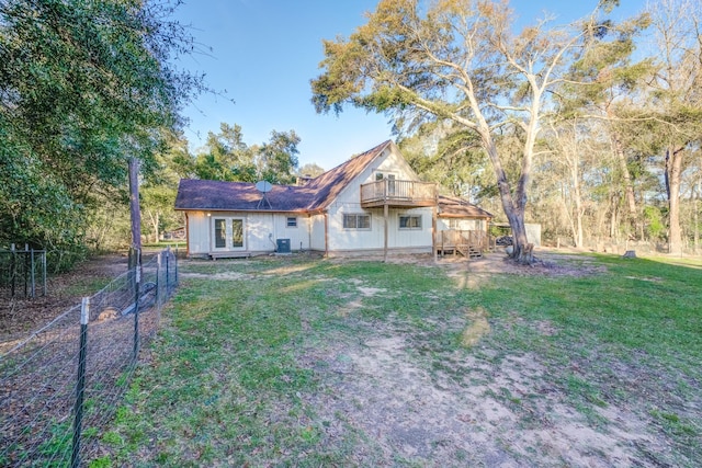 back of property with a wooden deck and a yard