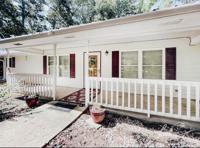 view of exterior entry with a porch